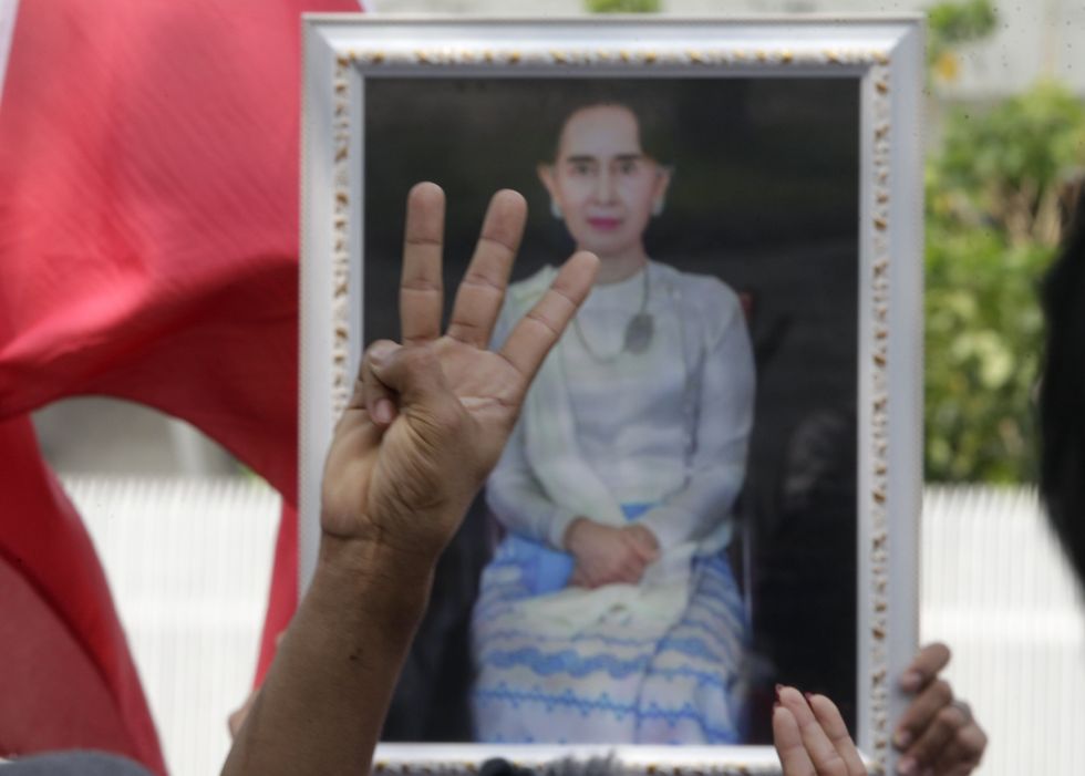 A protester makes a three-finger salute in front of a portrait of Aung San Suu Kyi during a rally to mark the third anniversary of the coup in Myanmar in front of the United Nations Building in Bangkok.