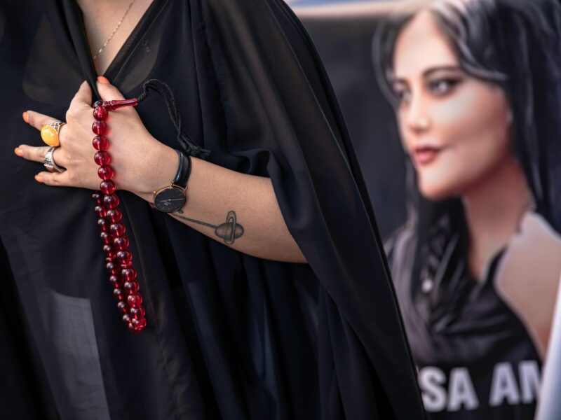 A protester seen holding a rosary and a placard with a picture of Mahsa Amini during the demonstration in Istanbul, Turkey, on Nov. 4