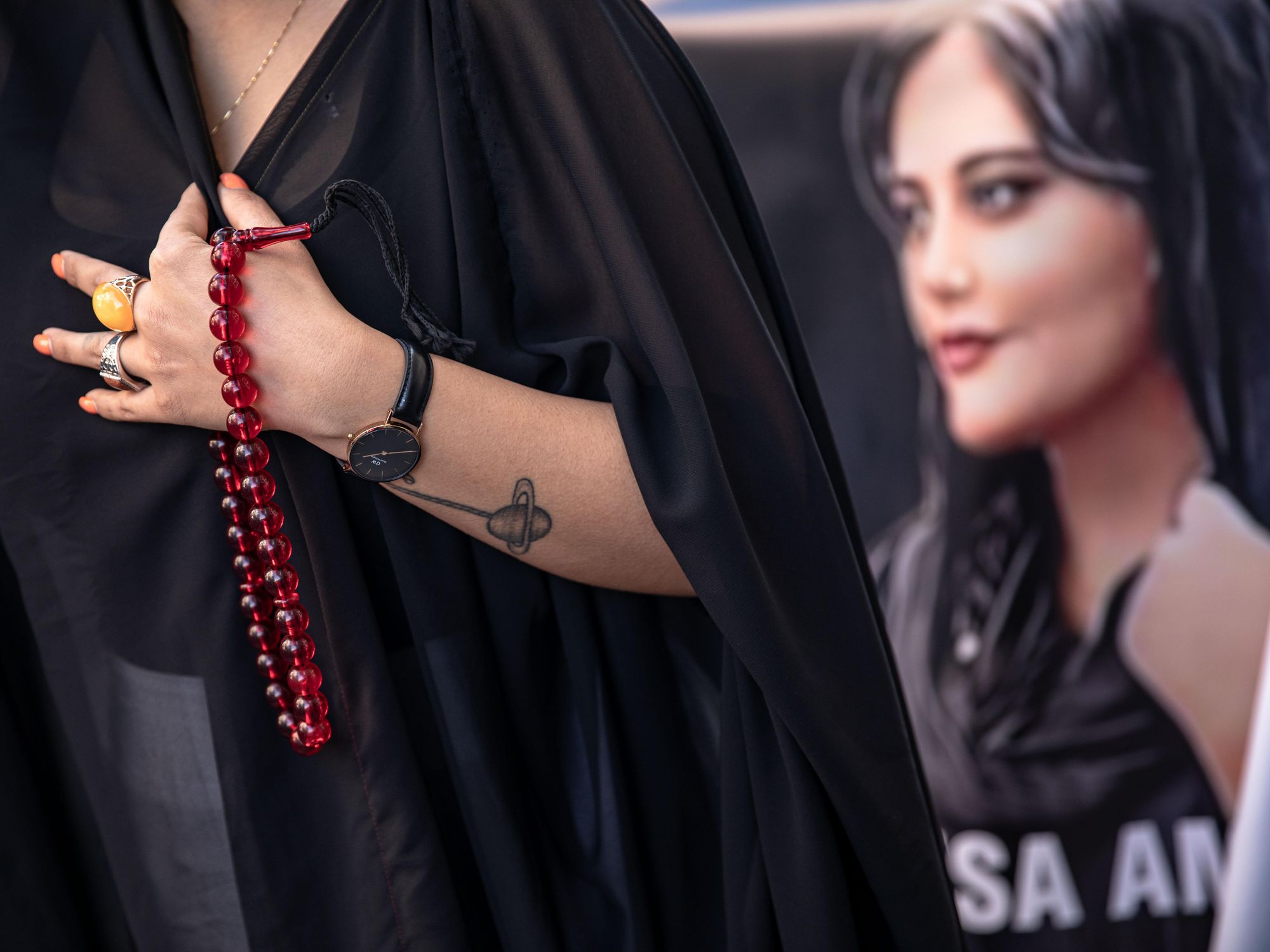 A protester seen holding a rosary and a placard with a picture of Mahsa Amini during the demonstration in Istanbul, Turkey, on Nov. 4