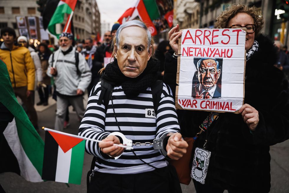 A protester wearing a mask of Israeli Prime Minister Benjamin Netanyahu.