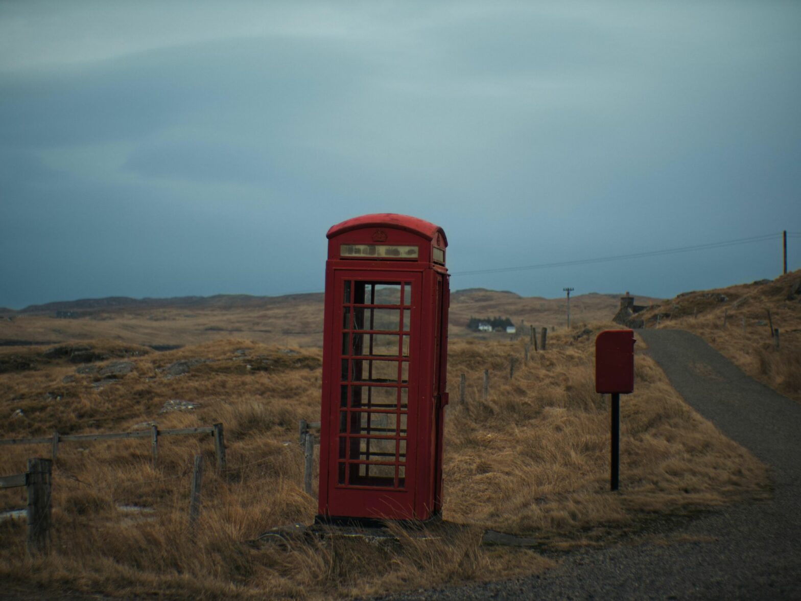 A red phone booth alongside the road
