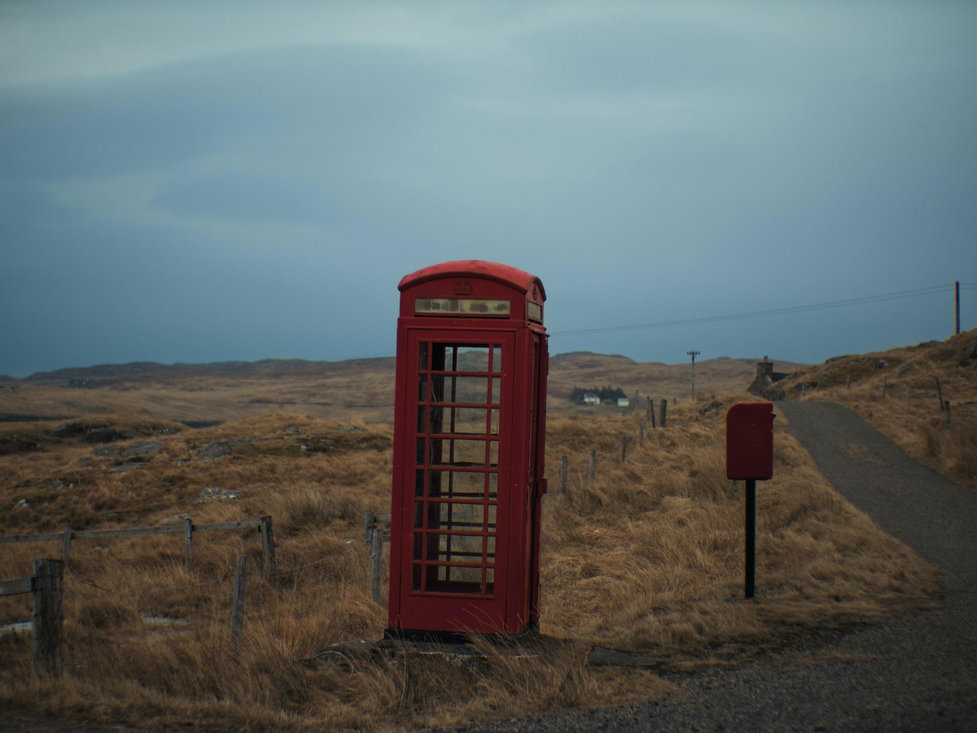 A red phone booth alongside the road