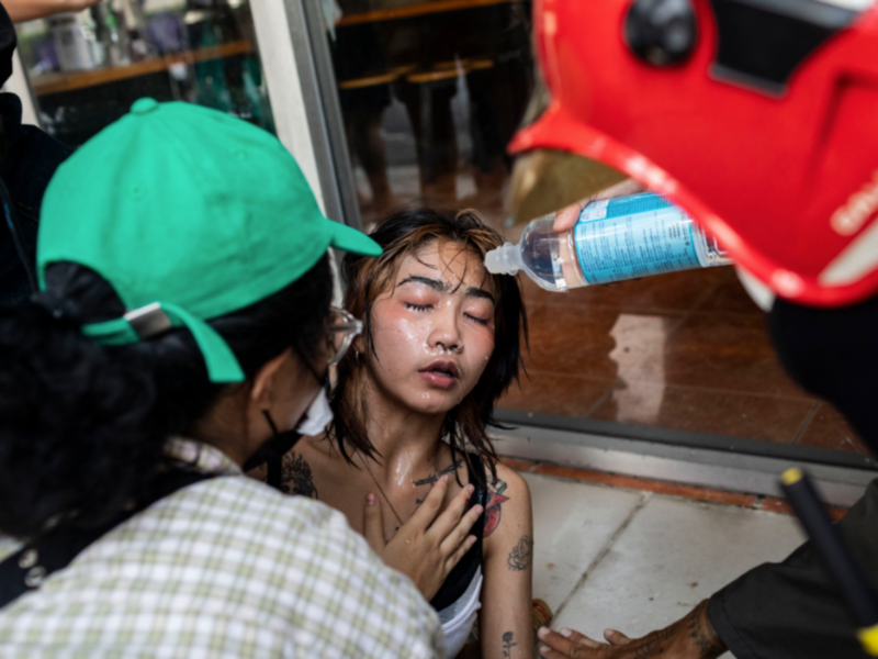 A rescuer pour water from a bottle on a protester's face after clashes during a pro-democracy rally in Bangkok on Sept. 29