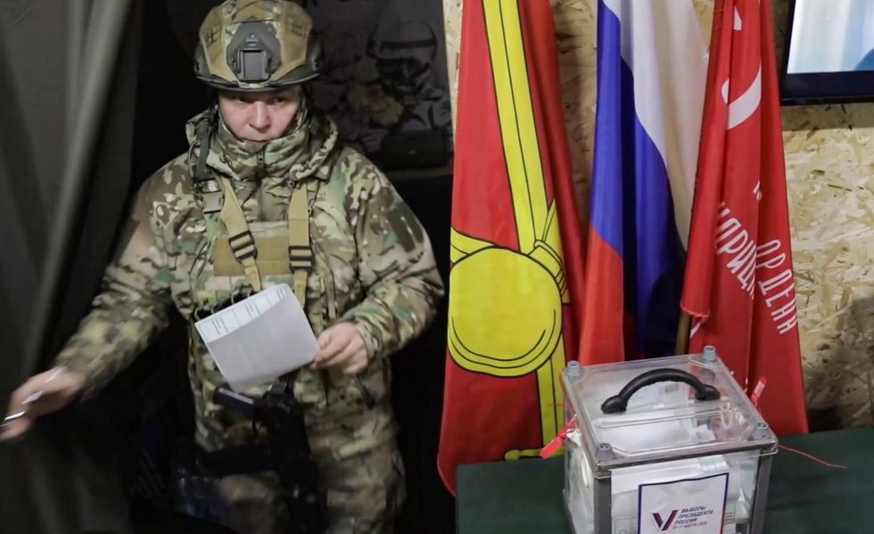 A serviceman of the 11th army corps of the Zapad West Group of the Russian Armed Forces leaves a voting booth during early voting in the 2024 Russian presidential election.