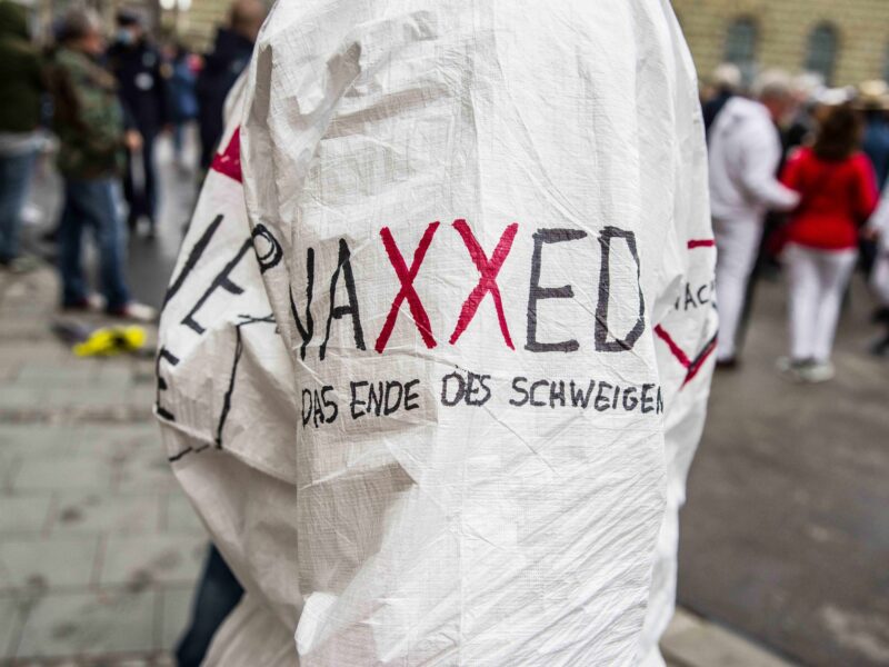 A sheet at a protest that says VAXXED