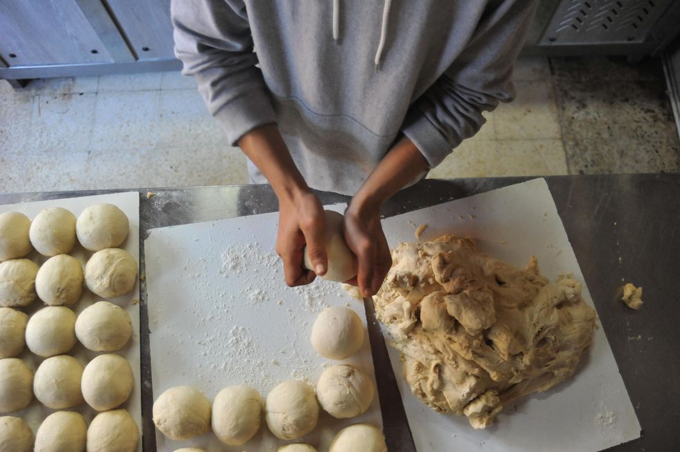 A skillful baker makes bread at a bakery in Tunis