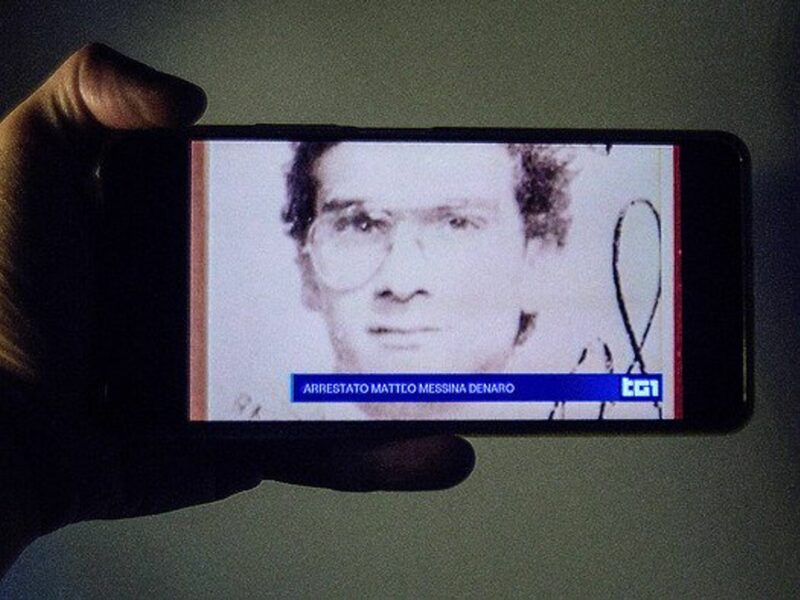 A smartphone screen with live news from an Italian television channel about the arrest of fugitive Matteo Messina Denaro.