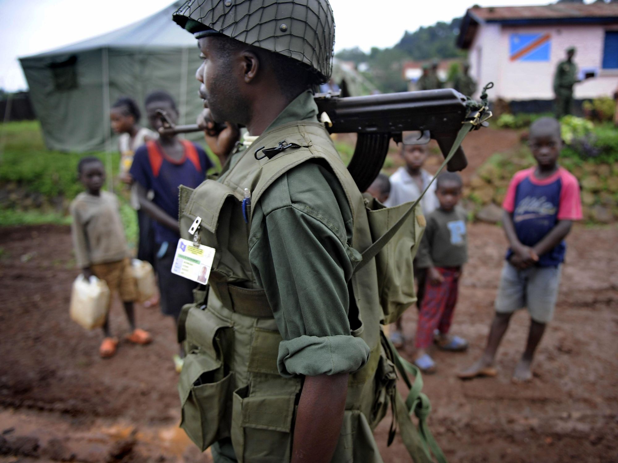 A soldier stands by children in Congo.