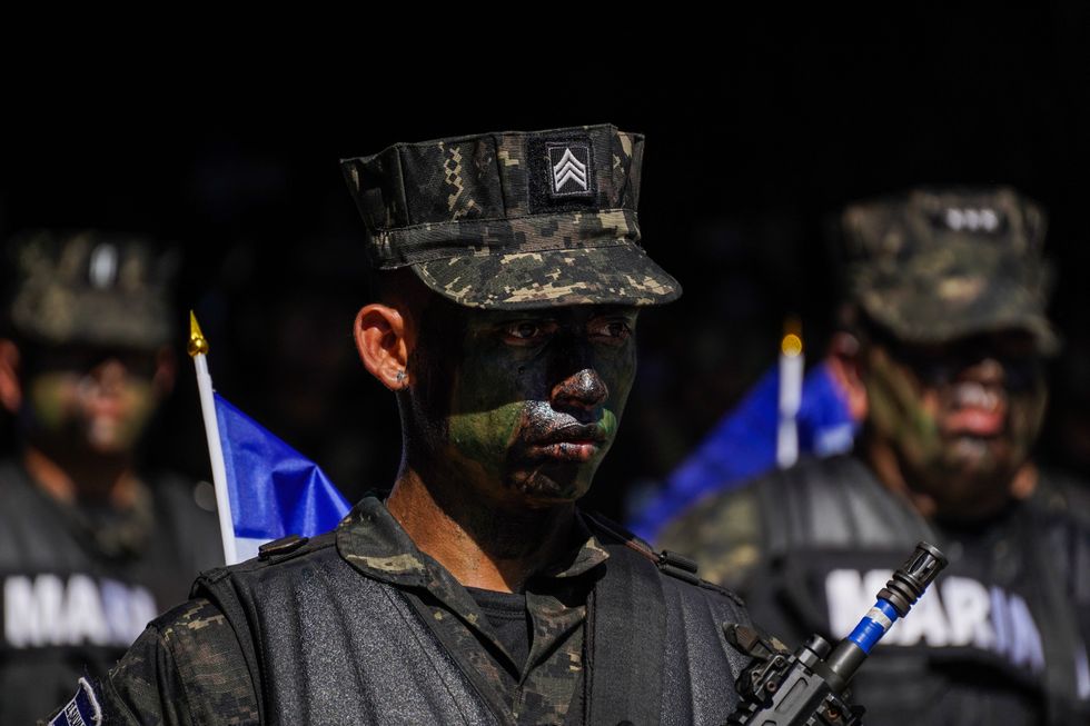 A soldier stands on guard as Salvadorans enjoy a military parade during El Salvador's independence day.