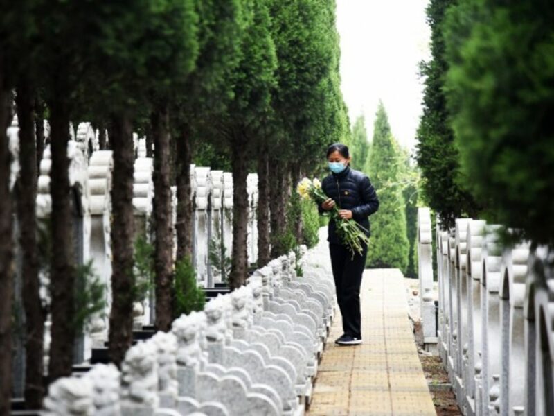 A staff member distributes flowers at a cemetery in Jinan, in eastern China.