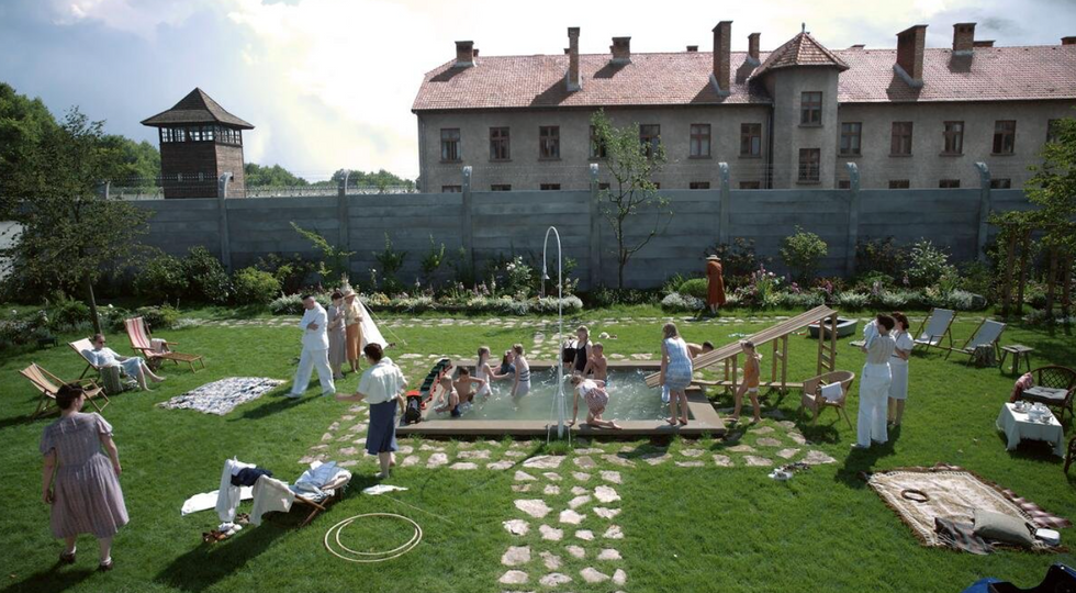 A still from the Oscar-nominated film "The Zone of Interest": people in a garden around a pool