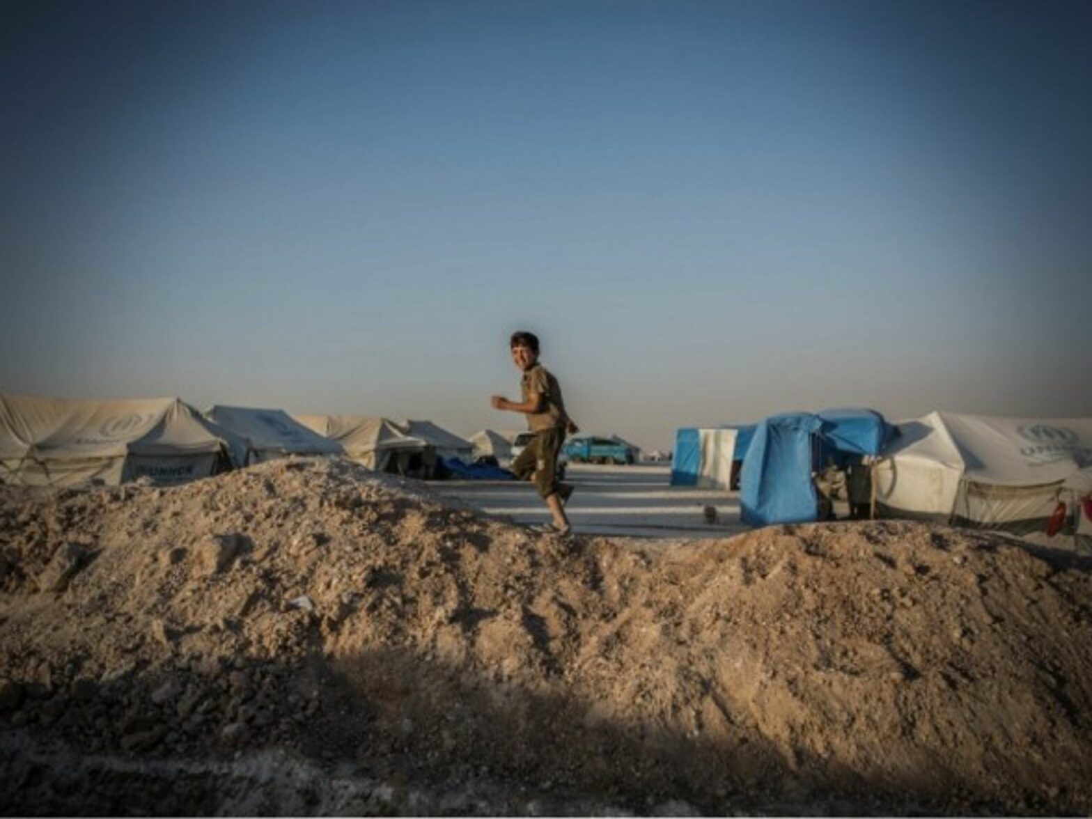 A Syrian boy running through a refugee camp in Ain Issa, Northern Syria