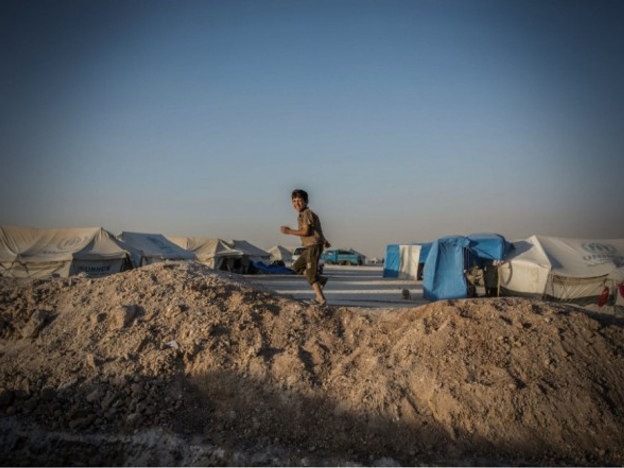 A Syrian boy running through a refugee camp in Ain Issa, Northern Syria