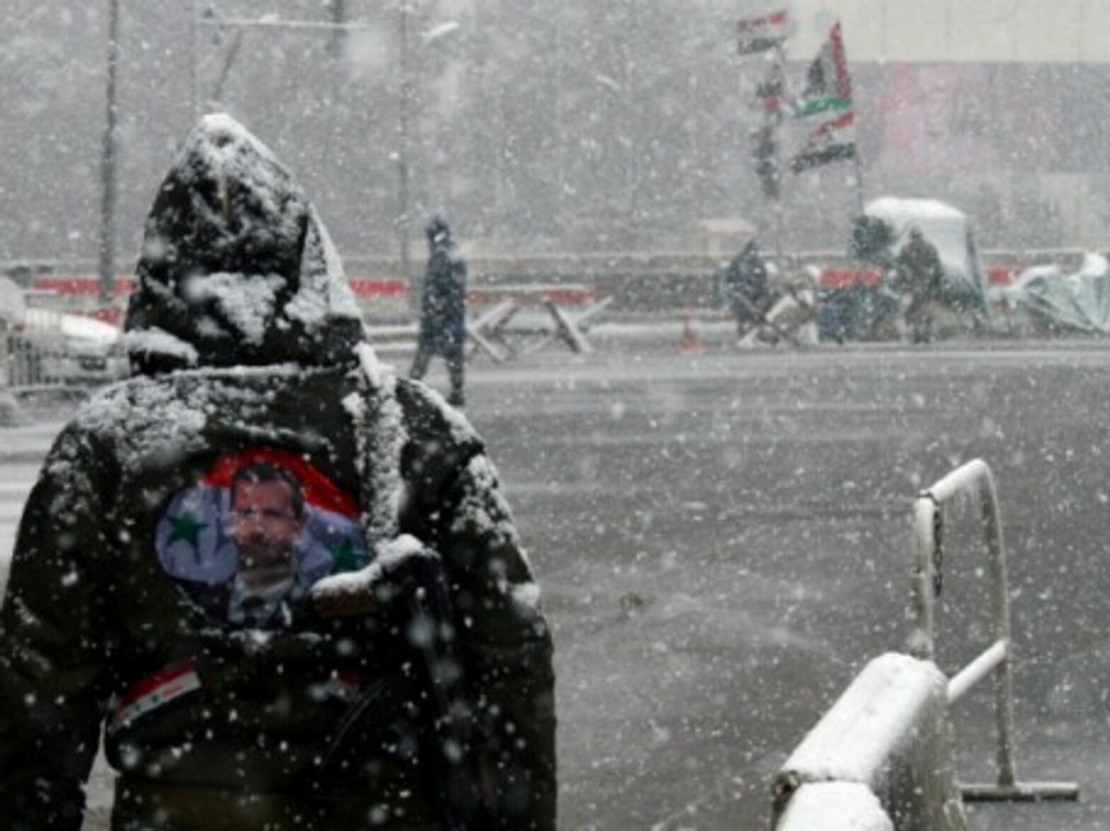 A Syrian government soldier stands in the snow in central Damascus.