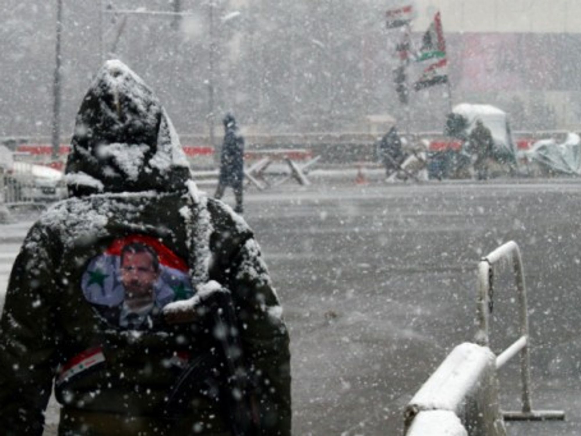 A Syrian government soldier stands in the snow in central Damascus.