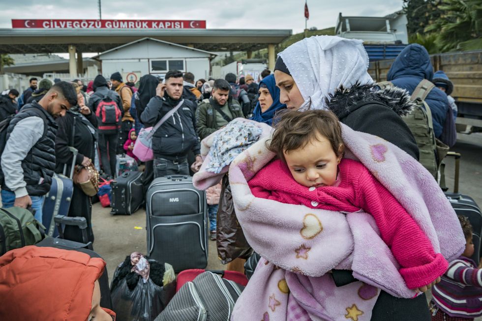 A Syrian mother and her baby wait at the Turkish border to return home after the devastating earthquake.