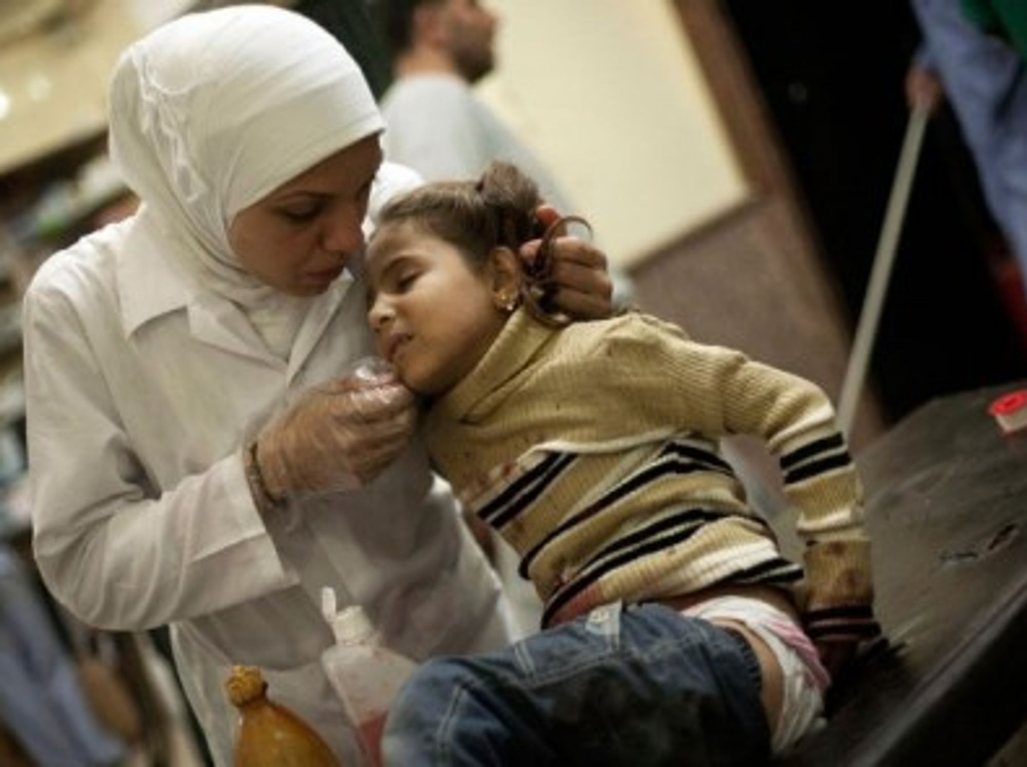 A Syrian nurse caring for a little girl after her house was bombed by Assad militias, in November 2012.