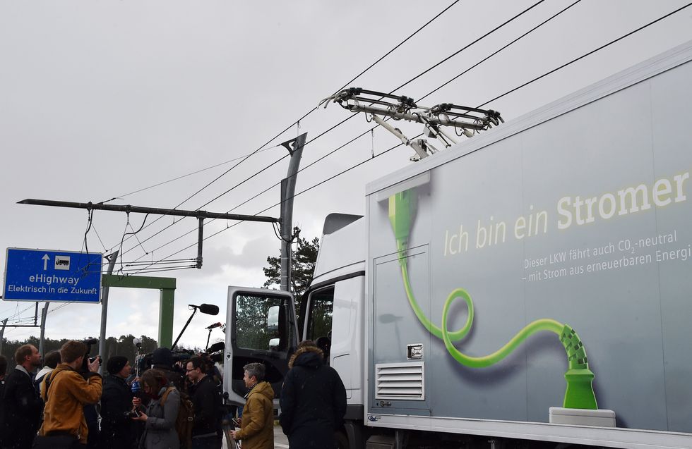 A truck powered by electric overhead lines drives along an 'eHighway' stretch of motorway operated by Siemens near Templin, Germany.