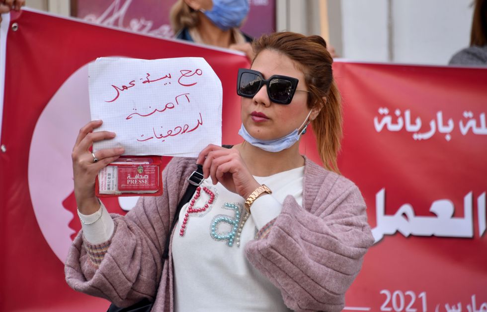 A Tunisian woman holding a sign in arabic.
