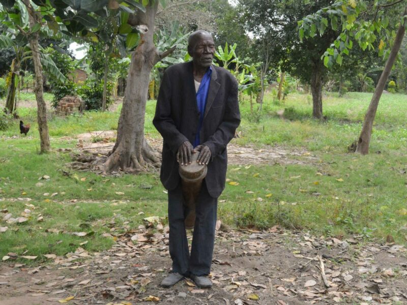 A Ugandan musician playing the fumbo during the ajore dance, a traditional burial rite