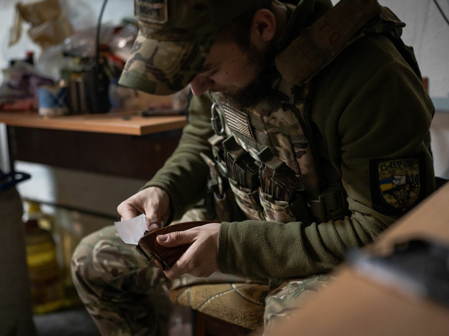 A Ukrainian soldier is seen cleaning the magazine filled with bullets in the base near Soledar.