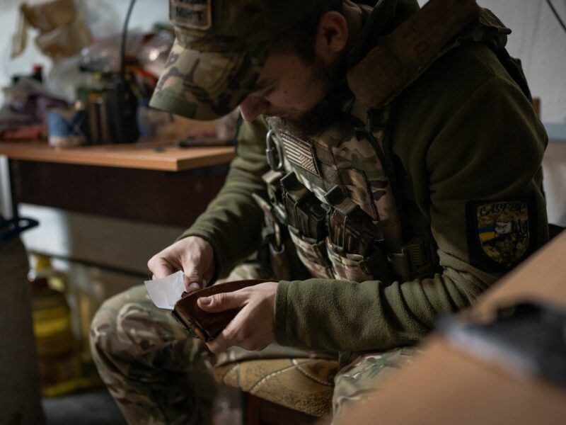 A Ukrainian soldier is seen cleaning the magazine filled with bullets in the base near Soledar.