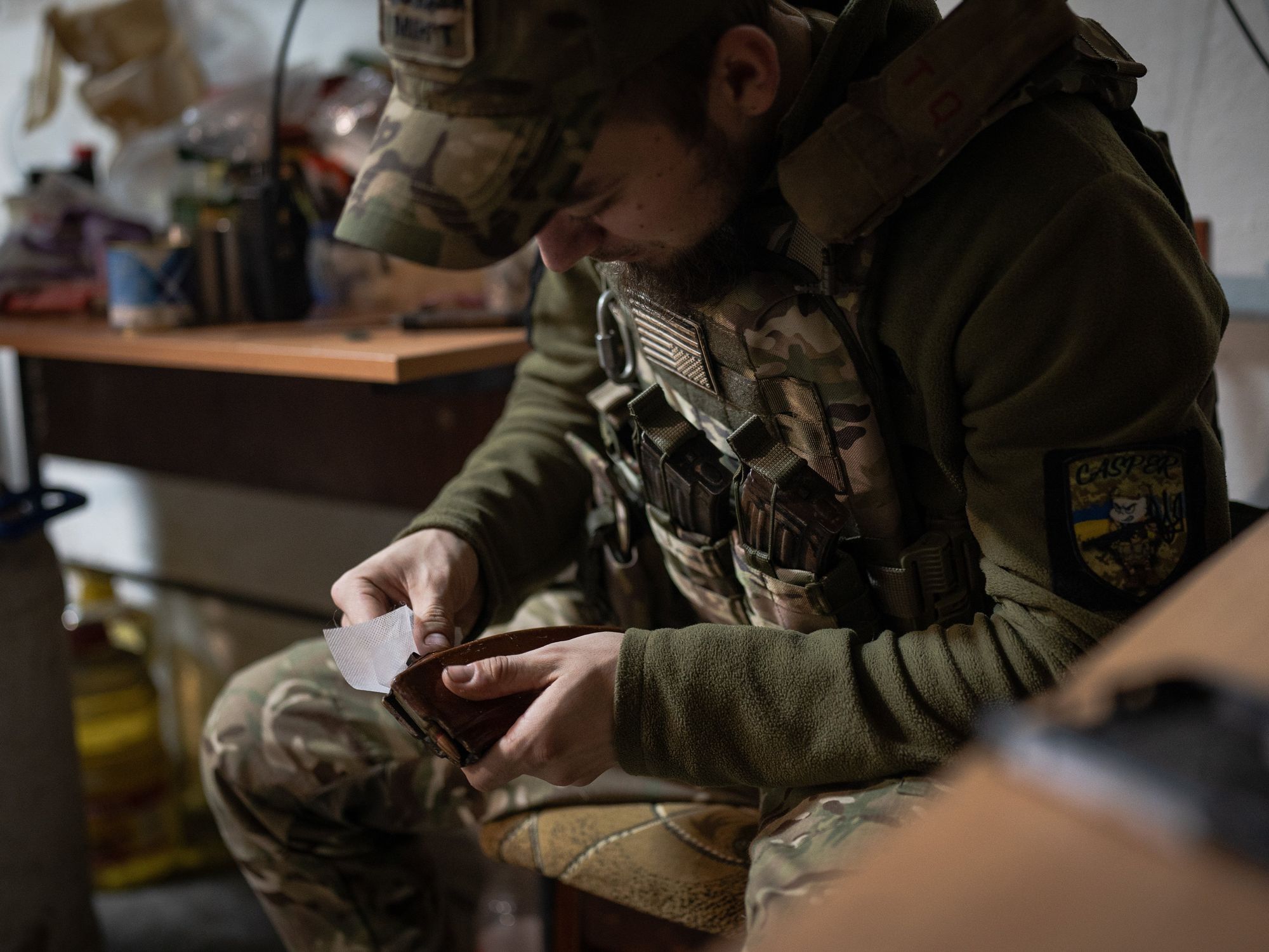 A Ukrainian soldier is seen cleaning the magazine filled with bullets in the base near Soledar.