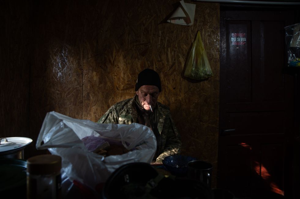 A Ukrainian soldier lights up a cigarette inside their positions.