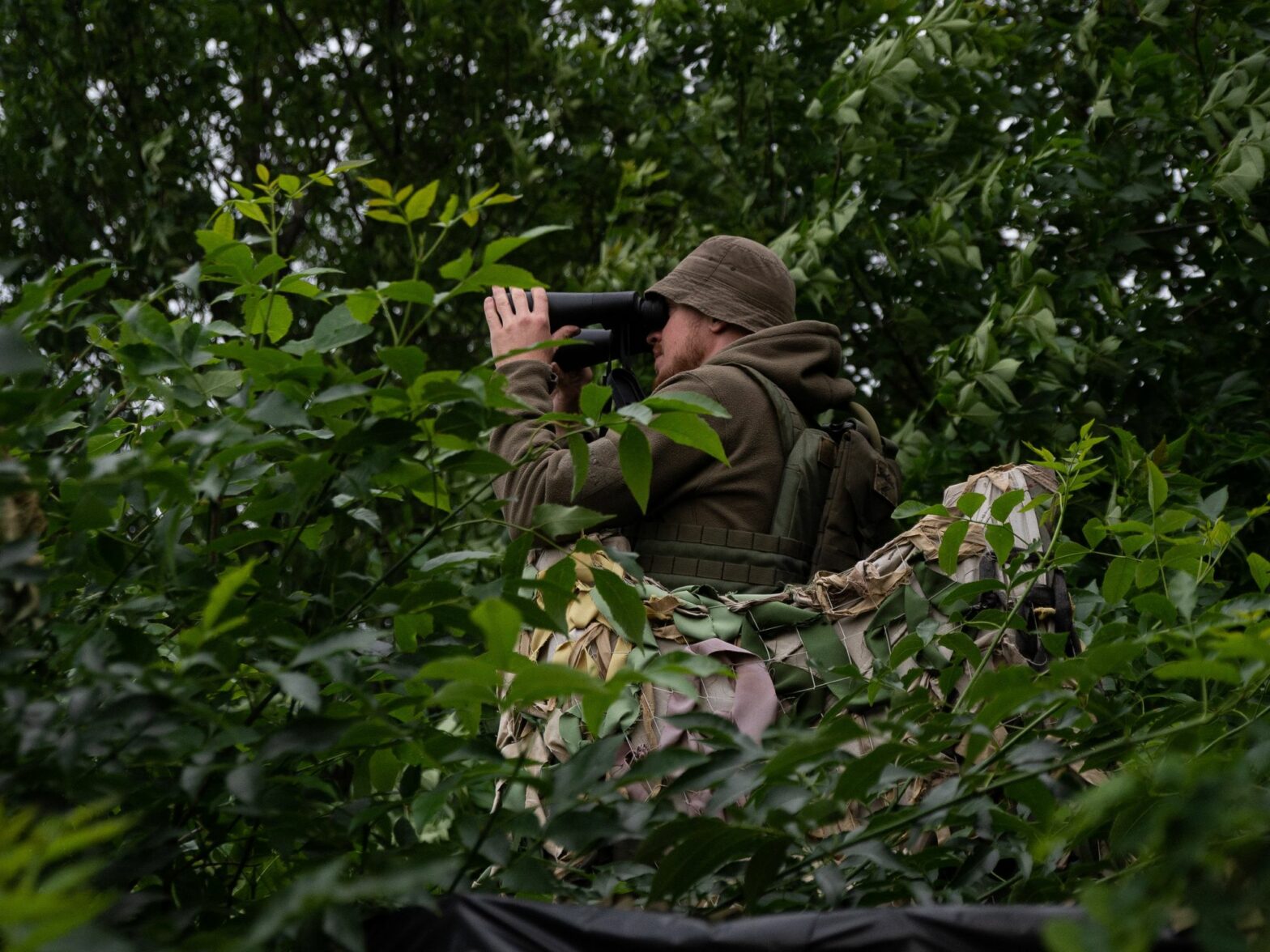 A Ukrainian soldier observes his enemies in the Kharkiv region.