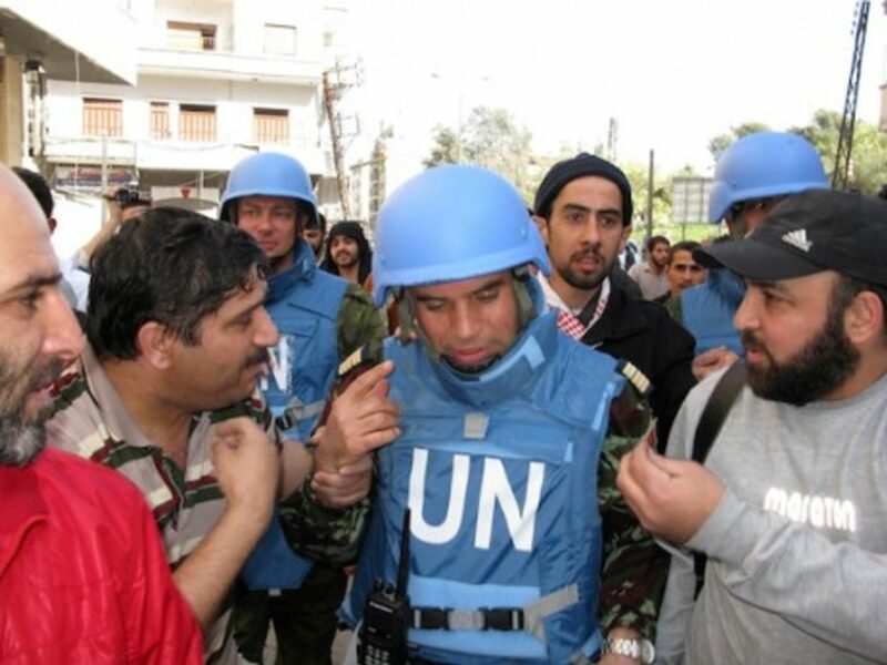 A UN Military officer surrounded by citizens of Homs (UN)