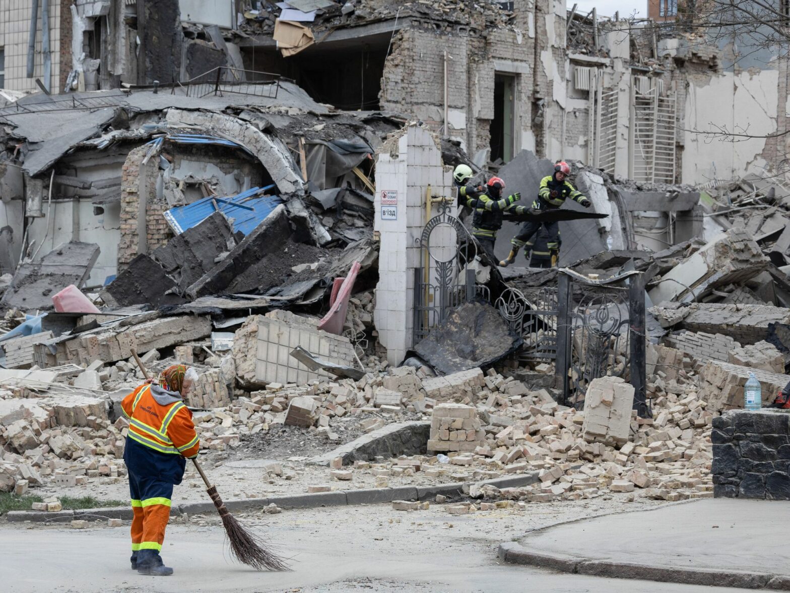 A utility worker removes rubble at the site of the building of Kyiv Academy of Art and Design.