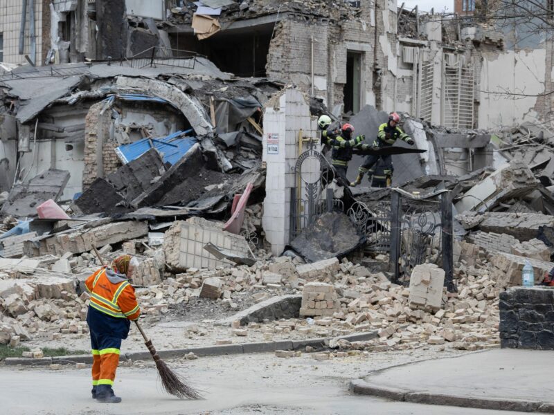 A utility worker removes rubble at the site of the building of Kyiv Academy of Art and Design.