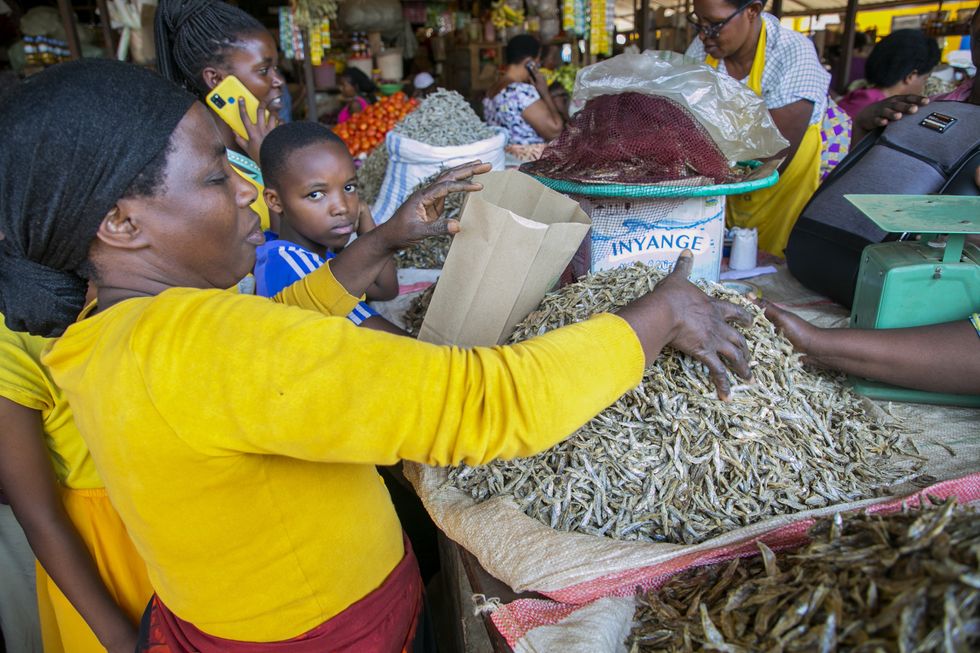 A vendor packs dried fish with a paper bag at Kimironko market in Kigali, Rwanda