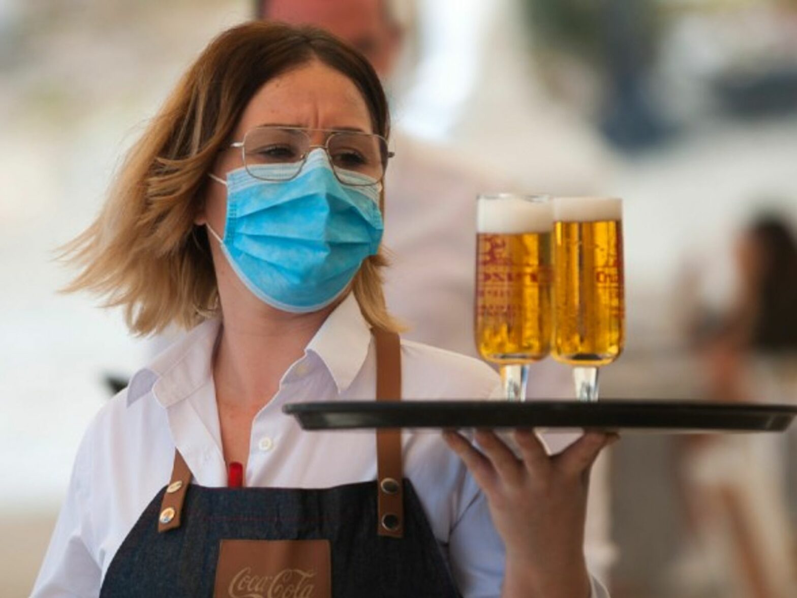 A waiter serves drinks during the nationwide partial lockdown in Malaga, Spain.