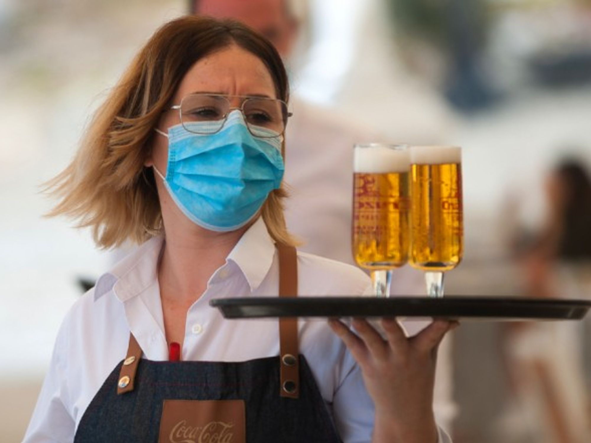 A waiter serves drinks during the nationwide partial lockdown in Malaga, Spain.