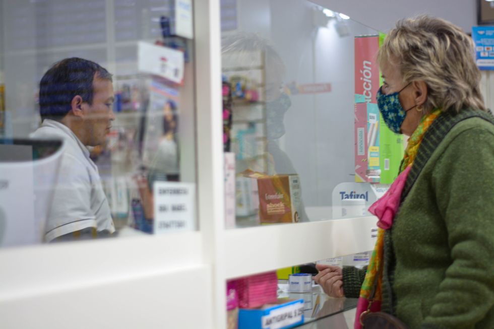 A woman buying drugs at a pharmacy.