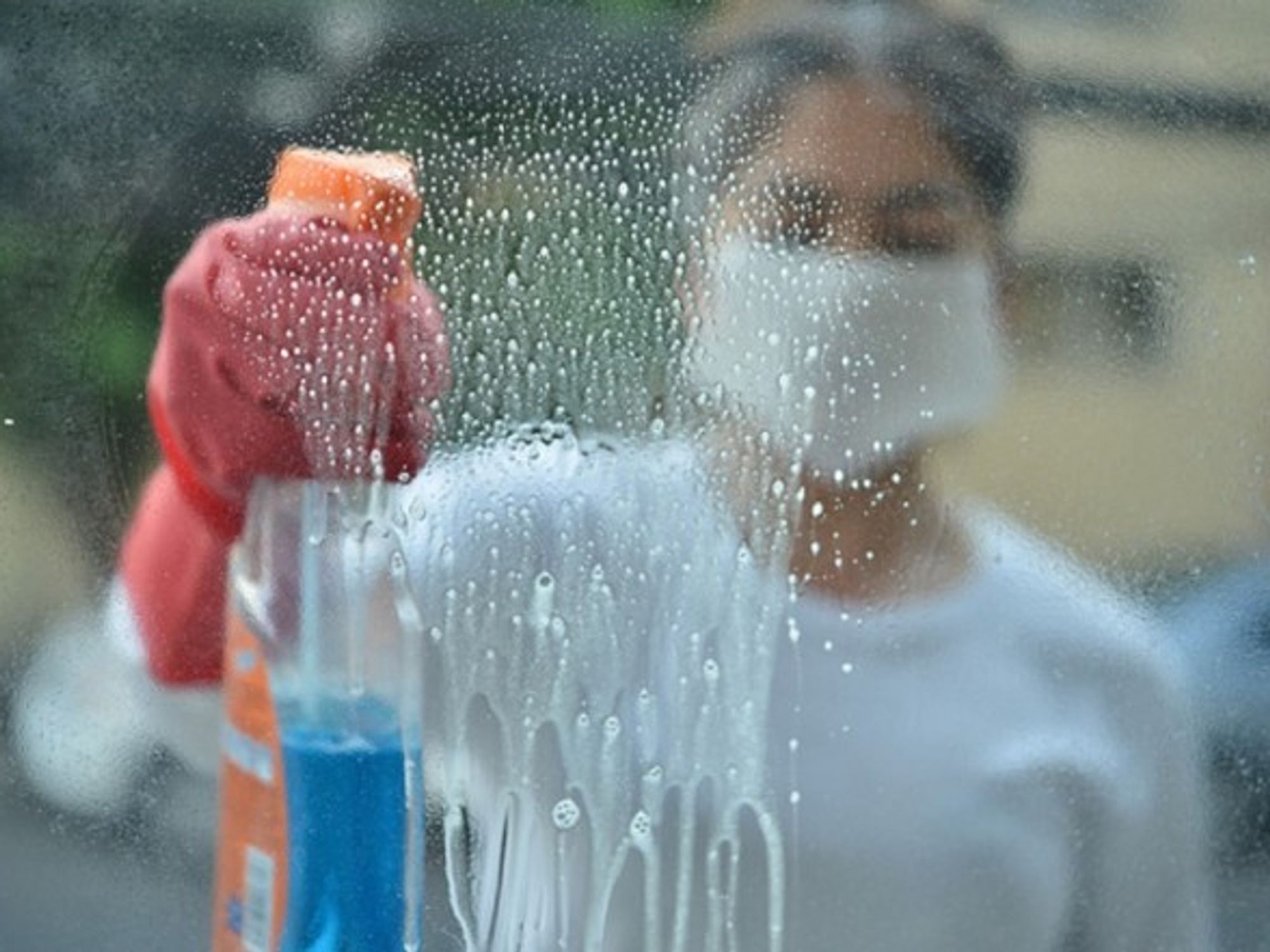 A woman disinfects surfaces with cleaning products in Mexico City