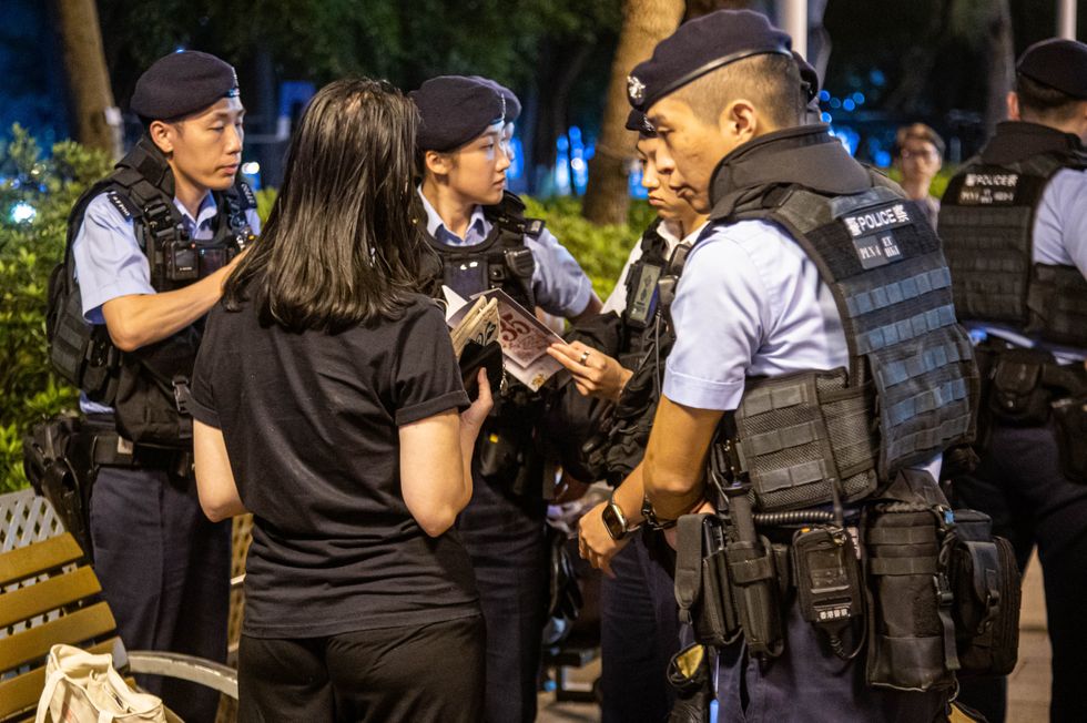 A woman has her bag and belongings searched by police in Hong Kong: she was participating in a commemoration ceremony for those who lost their lives in Tiananmen Square on June 4, 1989.