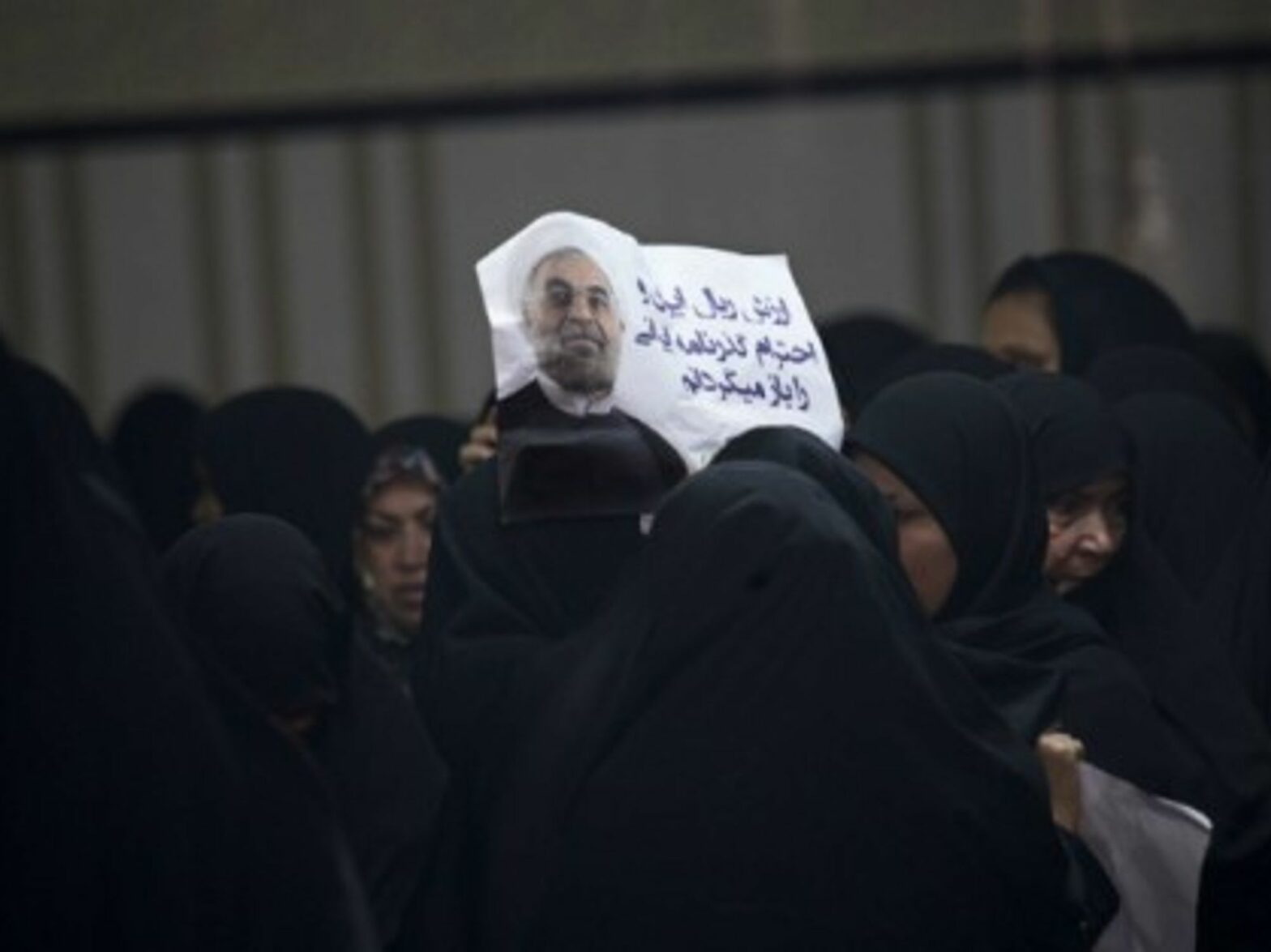 A woman helds up a poster of Iran president Hassan Rouhani