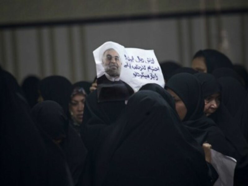 A woman helds up a poster of Iran president Hassan Rouhani