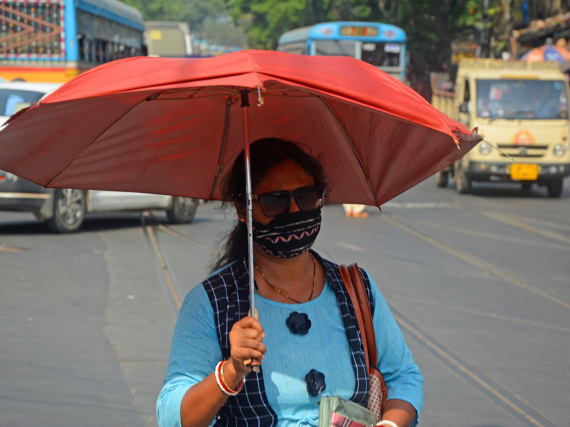 A woman hides from the sun under an umbrella in Kolkota.
