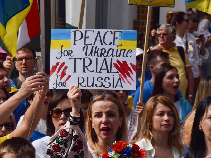 A woman holding a peace fo Ukraine trial for russia sign during a protest in London