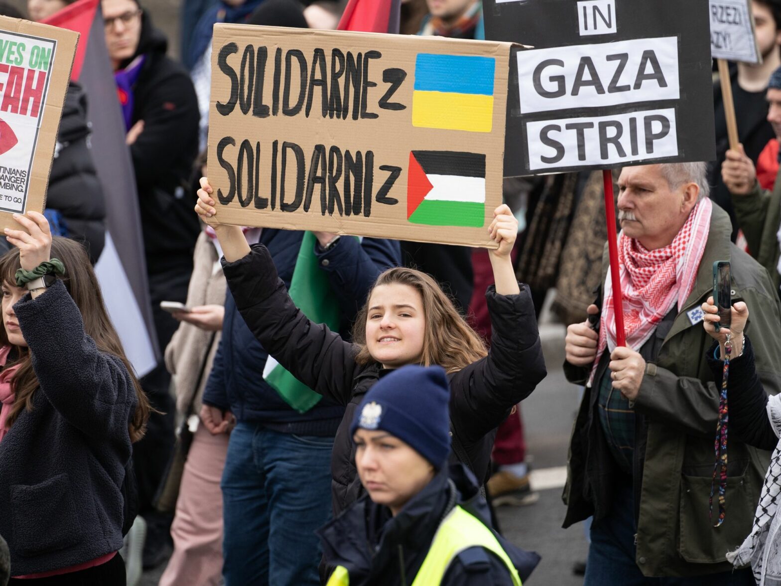 A woman holds a banner that says: ''Solidarity with Ukraine.Solidarity with Palestine'' at the Solidarity with Palestine rally in Warsaw.