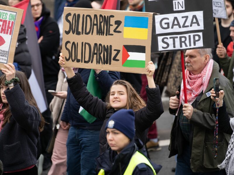 A woman holds a banner that says: ''Solidarity with Ukraine.Solidarity with Palestine'' at the Solidarity with Palestine rally in Warsaw.