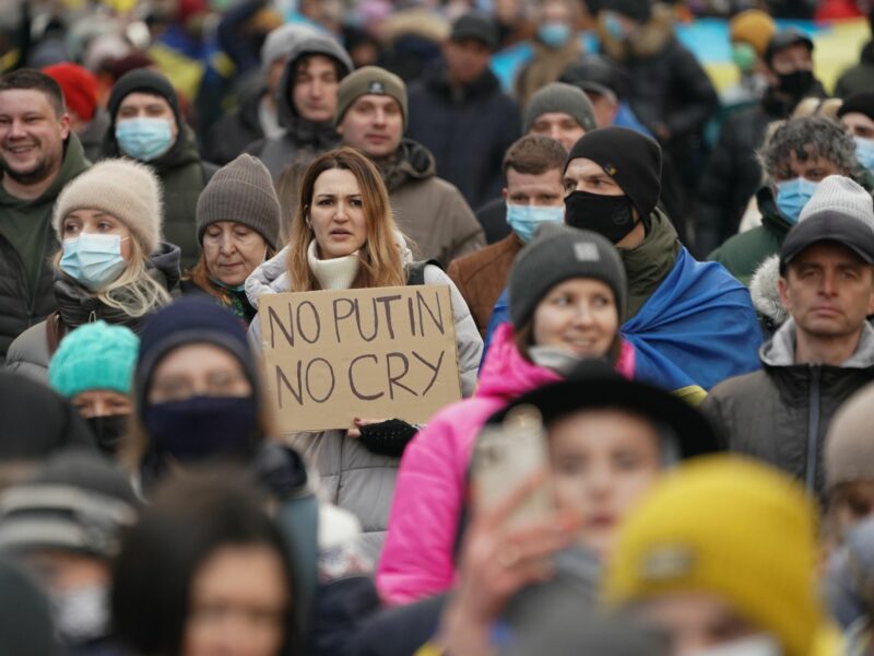 A woman holds a sign as Ukrainians march in solidarity against Russian aggression through the street of Kyiv on February 12 2022 in Ukraine