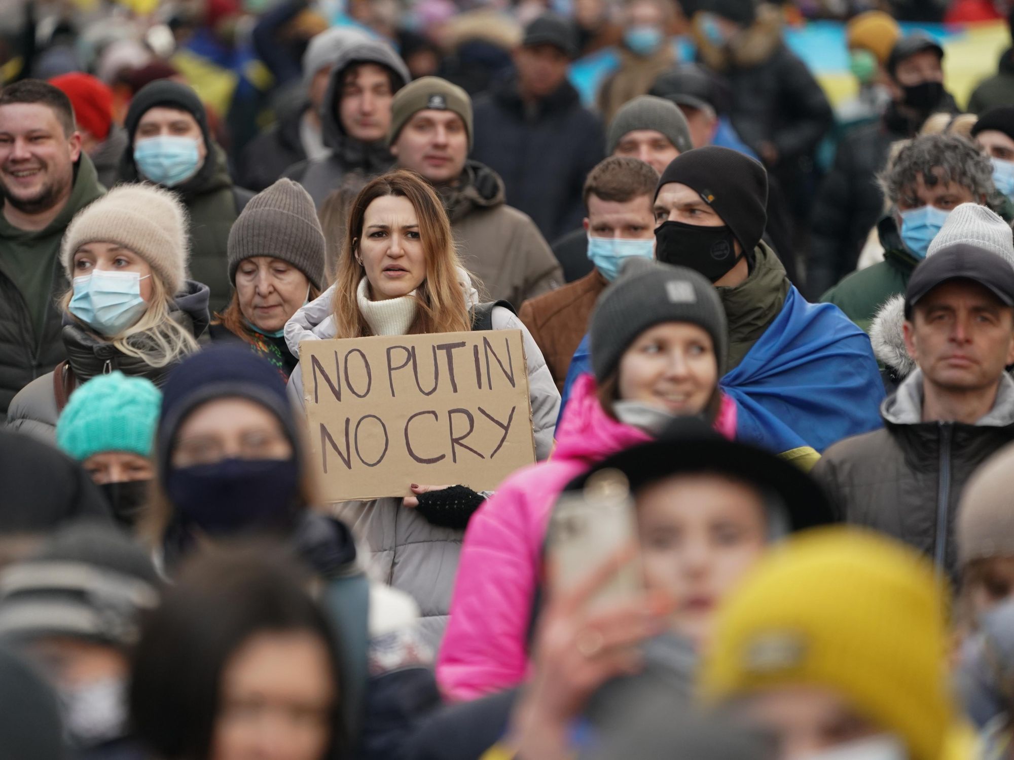 A woman holds a sign as Ukrainians march in solidarity against Russian aggression through the street of Kyiv on February 12 2022 in Ukraine