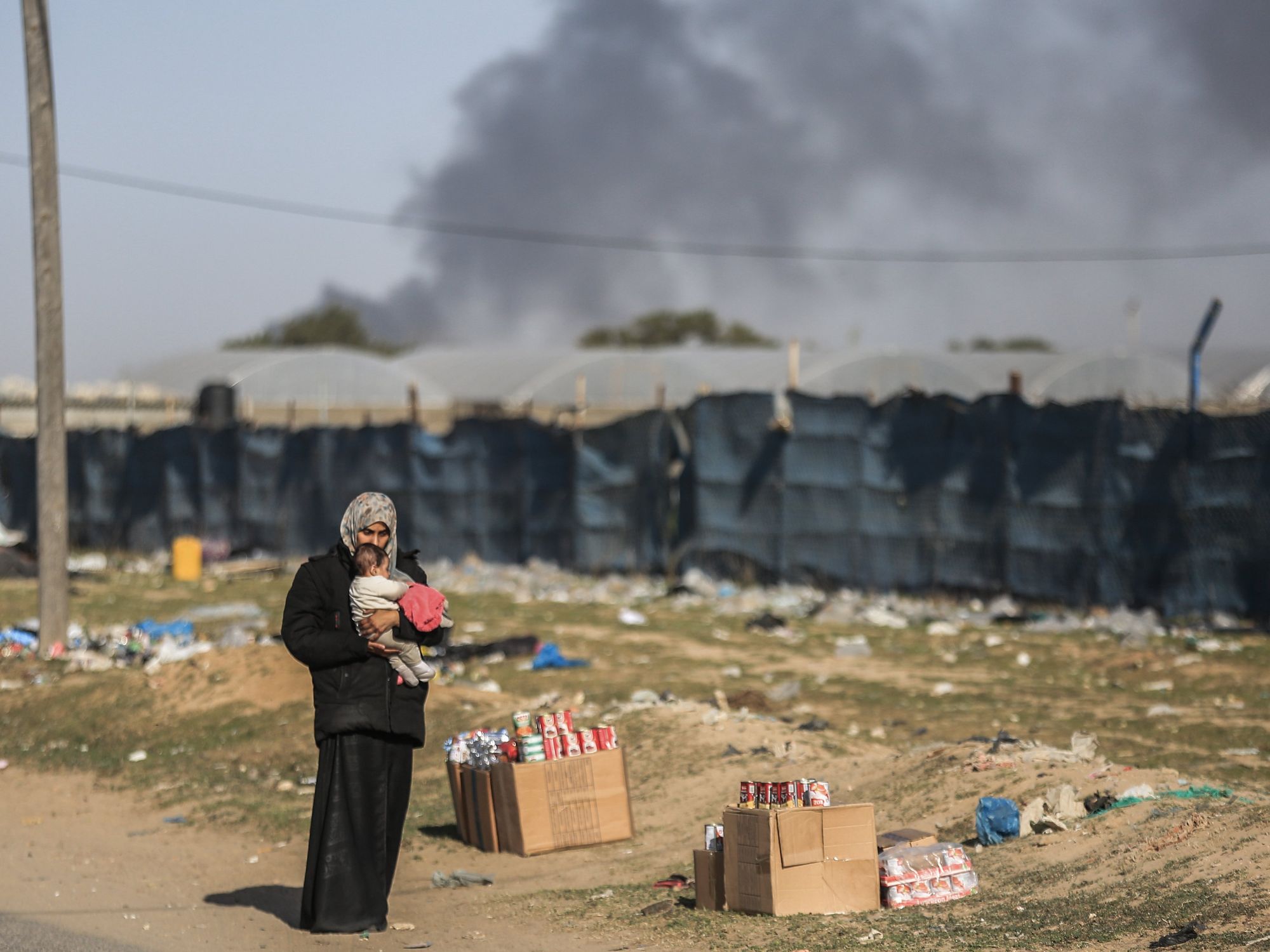 A woman holds a toddler as Palestinian families flee the city of Khan Yunis.