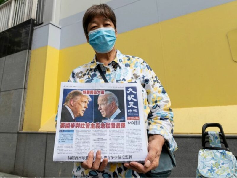 A woman in Hong Kong distributes copies of the Epoch Times