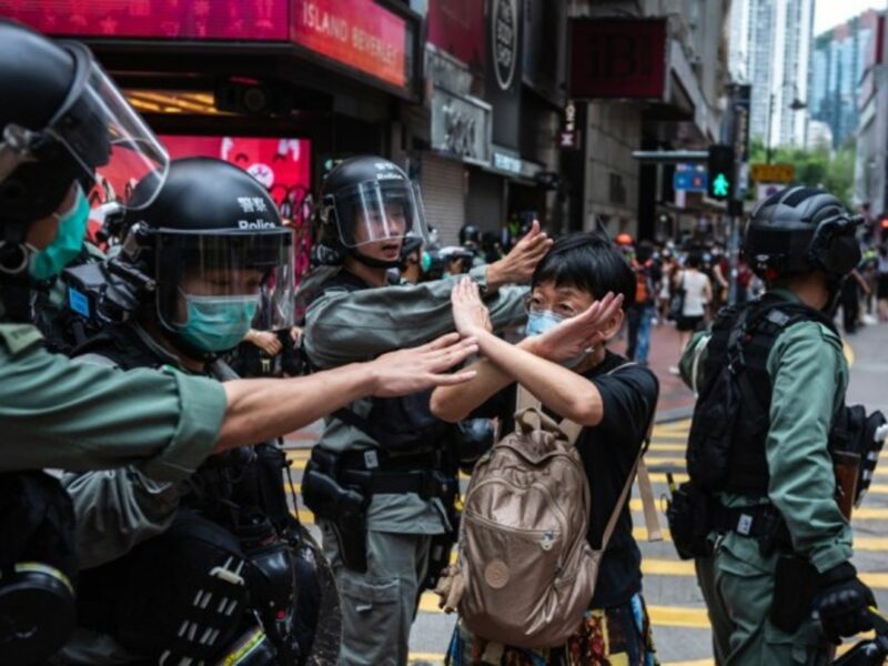 A woman in Hong Kong makes a gesture in front of riot police during a protest.