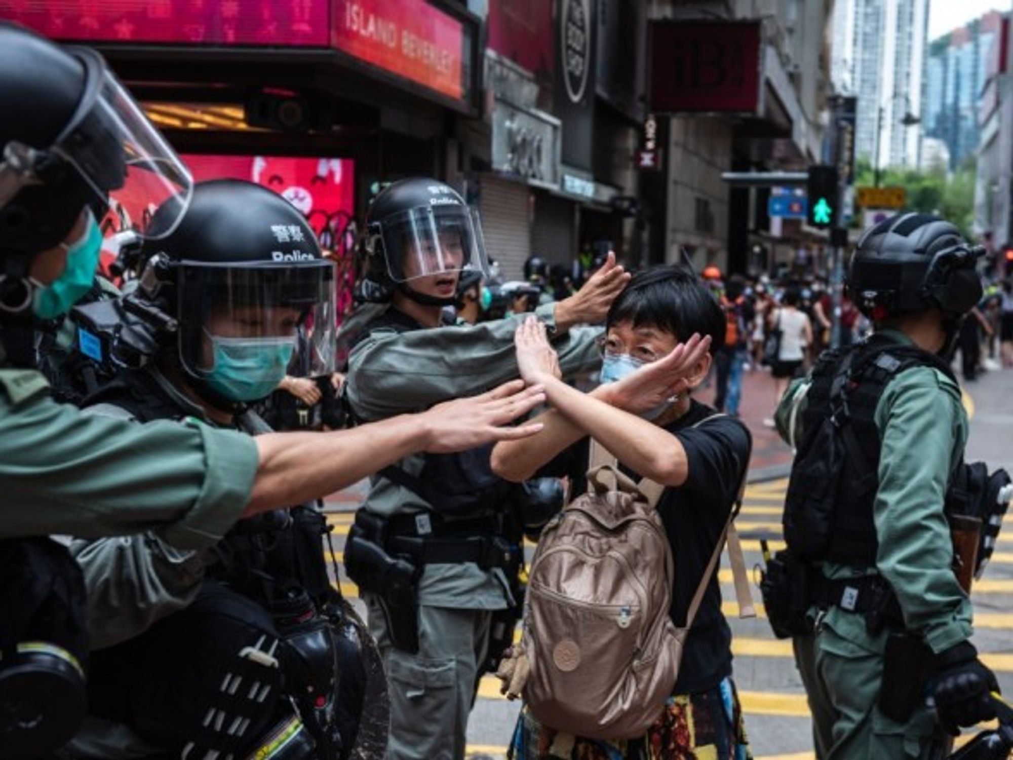 A woman in Hong Kong makes a gesture in front of riot police during a protest.
